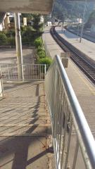 Ograja na stopnišču, ki povezuje železniško postajo in nadvoz. 